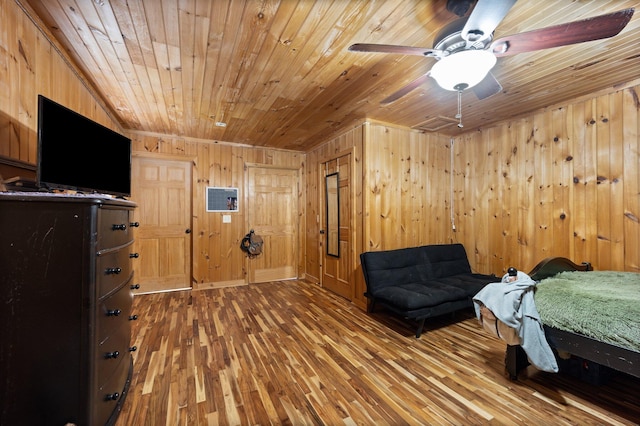 bedroom with ceiling fan, wood walls, hardwood / wood-style floors, and wooden ceiling