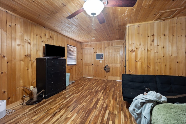 living room featuring hardwood / wood-style flooring, wooden walls, ceiling fan, and wooden ceiling