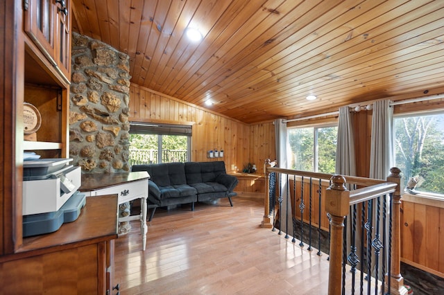 living room featuring wooden walls, wooden ceiling, and a wealth of natural light