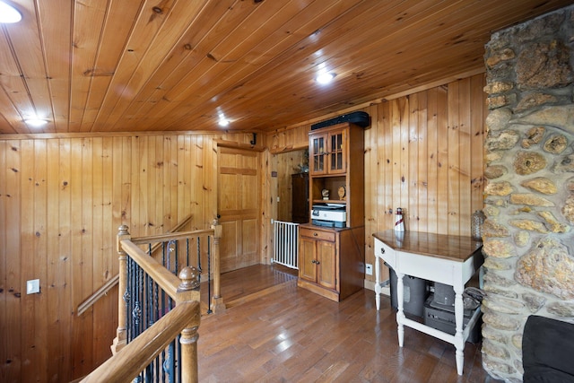 hallway with wooden walls, wood ceiling, and dark hardwood / wood-style floors