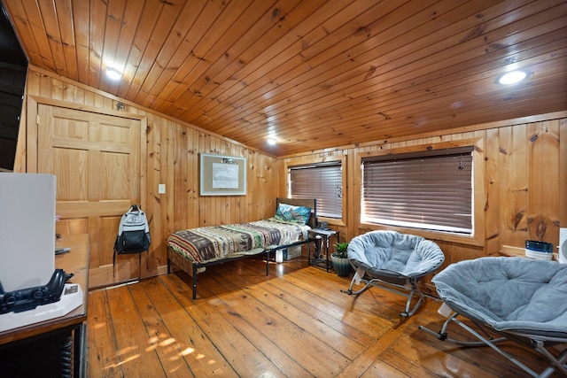 bedroom with lofted ceiling, wooden walls, hardwood / wood-style floors, and wood ceiling