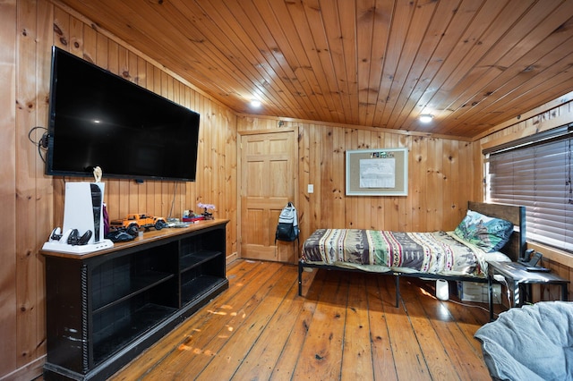 bedroom featuring wood ceiling, vaulted ceiling, hardwood / wood-style flooring, and wooden walls