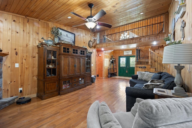 living room with ceiling fan, french doors, wood ceiling, wood-type flooring, and wood walls