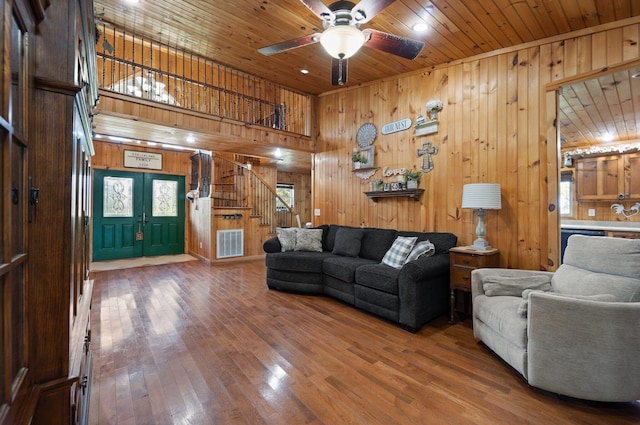 living room featuring hardwood / wood-style flooring, wooden walls, wooden ceiling, and french doors