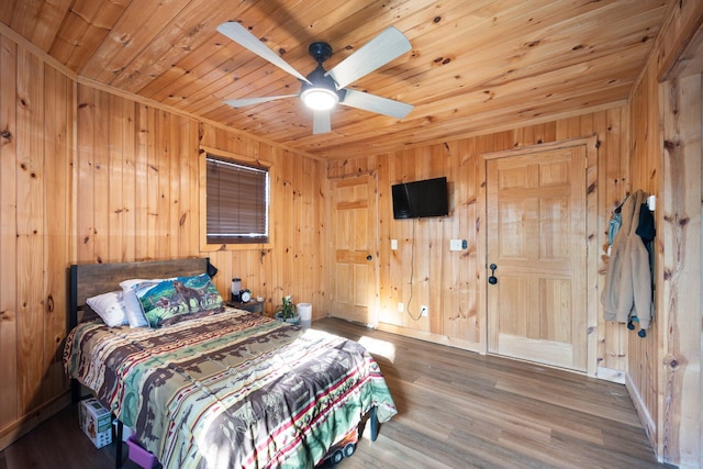 bedroom featuring wood-type flooring, wood ceiling, wooden walls, and ceiling fan