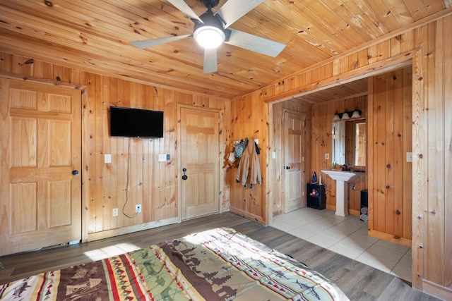 bedroom with wooden walls, wood ceiling, and light hardwood / wood-style flooring