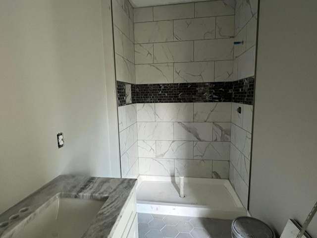 bathroom with tile patterned floors, tiled shower, and vanity