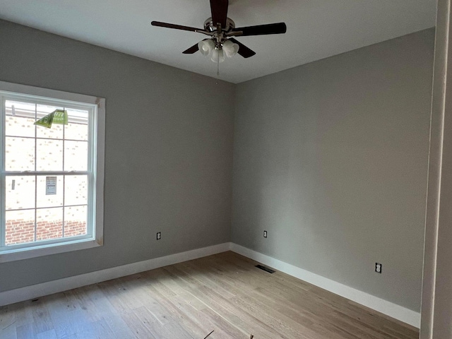 spare room featuring ceiling fan, light hardwood / wood-style flooring, and a healthy amount of sunlight