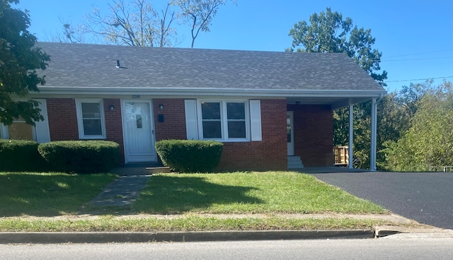 view of front of house featuring a carport and a front yard