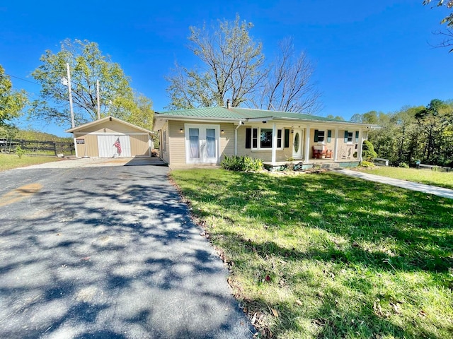 single story home featuring a storage shed, a front yard, and covered porch