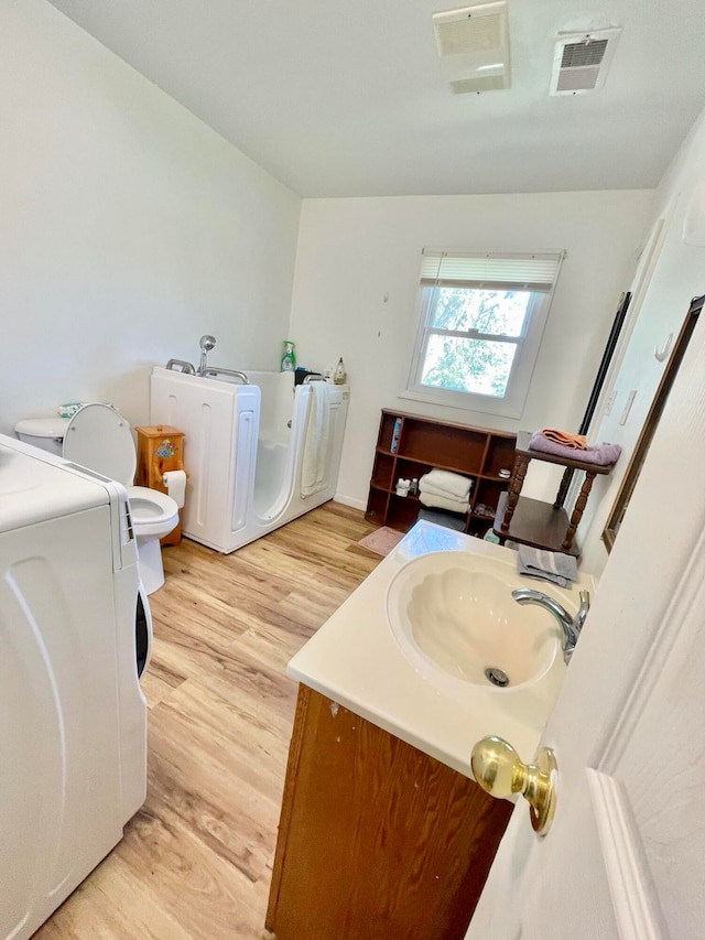 bathroom featuring wood-type flooring, vanity, and toilet