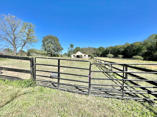 view of gate featuring a rural view and a yard