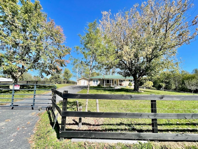 view of front of house with a rural view, a front yard, and a garage