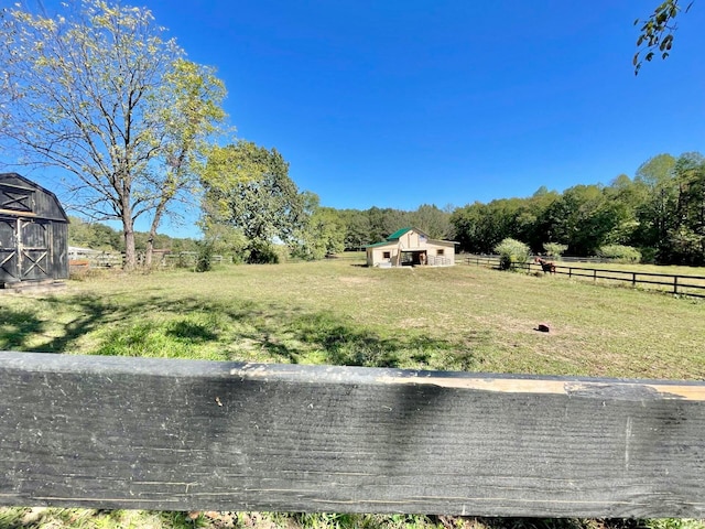 view of yard with a rural view and a storage shed