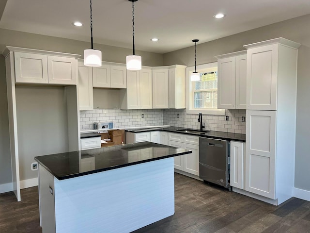 kitchen featuring hanging light fixtures, stainless steel dishwasher, and white cabinetry