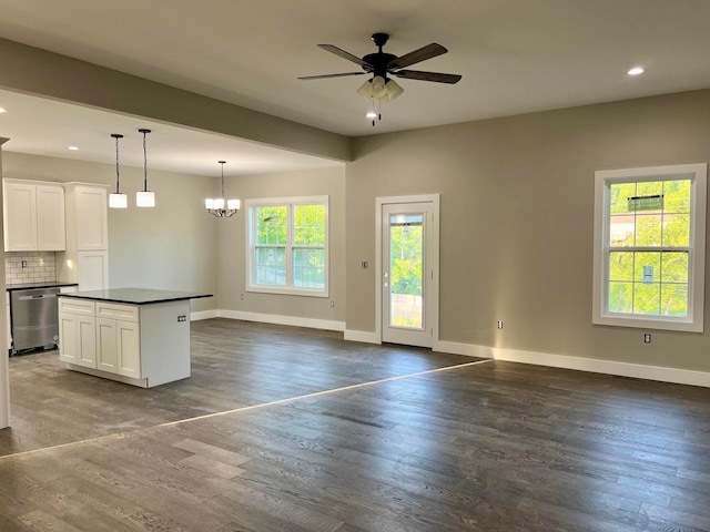 kitchen featuring white cabinets, pendant lighting, stainless steel dishwasher, dark hardwood / wood-style flooring, and decorative backsplash