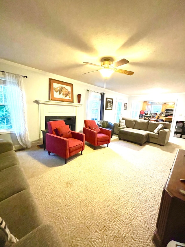 carpeted living room with crown molding and ceiling fan