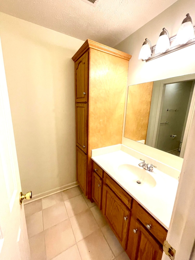 bathroom with tile patterned floors, vanity, and a textured ceiling