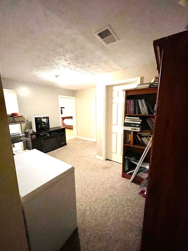 corridor featuring carpet and a textured ceiling