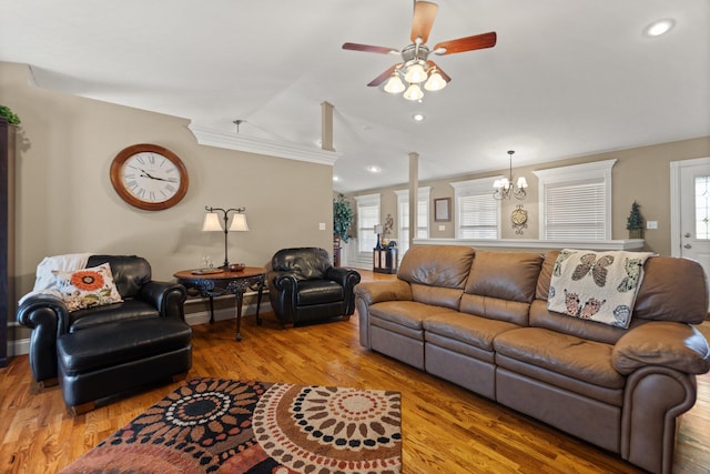 living room with ceiling fan with notable chandelier, hardwood / wood-style flooring, and lofted ceiling