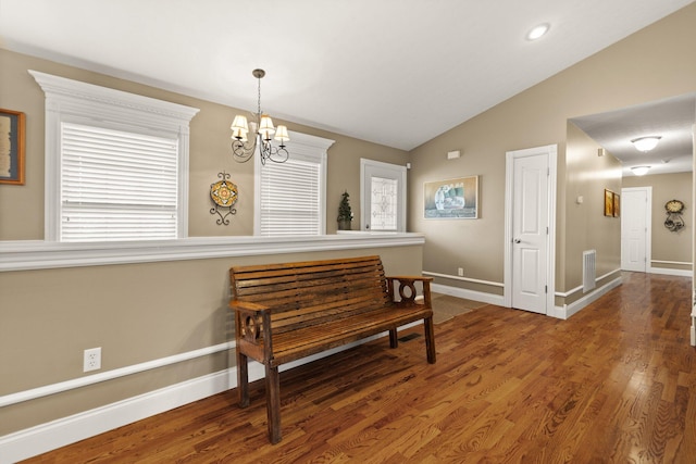 interior space with lofted ceiling, a chandelier, and dark hardwood / wood-style flooring