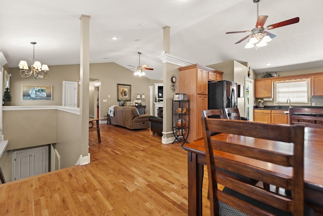 dining area with an inviting chandelier, lofted ceiling, light wood-type flooring, and sink