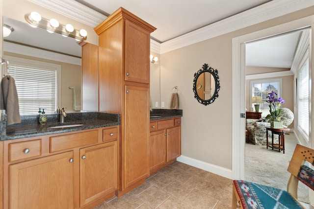 kitchen featuring lofted ceiling, dark stone countertops, sink, crown molding, and light colored carpet