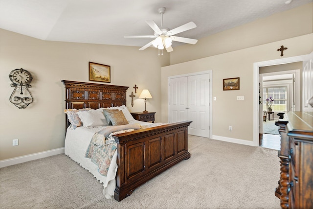 bedroom with lofted ceiling, a closet, ceiling fan, and light carpet