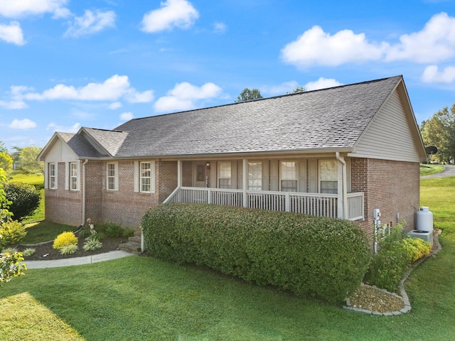 ranch-style house featuring a porch and a front yard