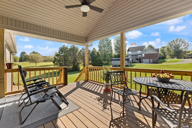 wooden terrace featuring a lawn and ceiling fan