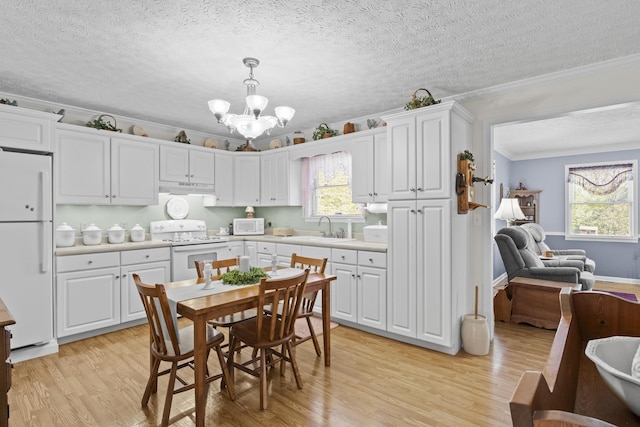 kitchen with a chandelier, crown molding, white appliances, and light wood-style floors