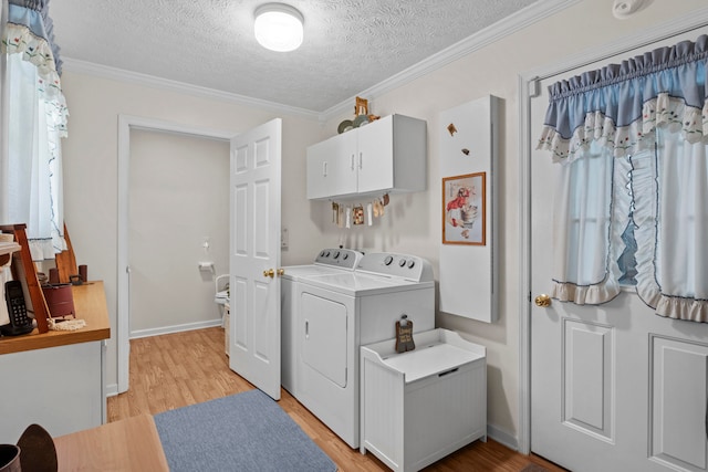 laundry room featuring light wood-type flooring, crown molding, independent washer and dryer, and a textured ceiling