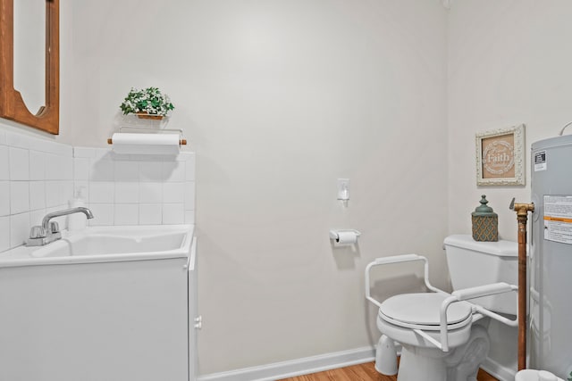 bathroom with hardwood / wood-style floors, vanity, electric water heater, toilet, and backsplash