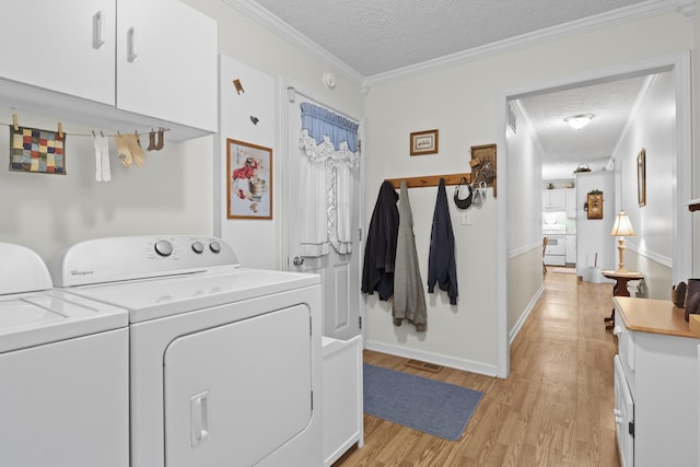 washroom with baseboards, ornamental molding, light wood-type flooring, a textured ceiling, and independent washer and dryer