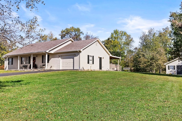 view of side of property featuring a garage, a lawn, and covered porch