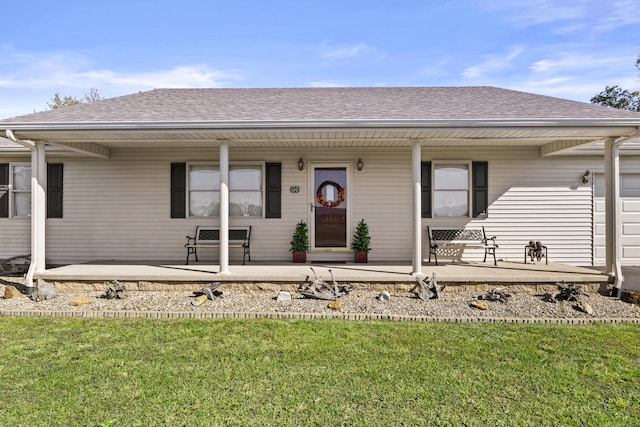 view of front of property with roof with shingles, a front lawn, and covered porch