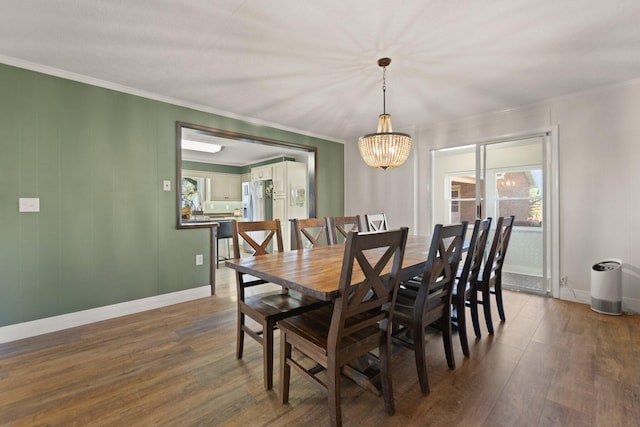 dining area with crown molding, an inviting chandelier, and dark hardwood / wood-style flooring