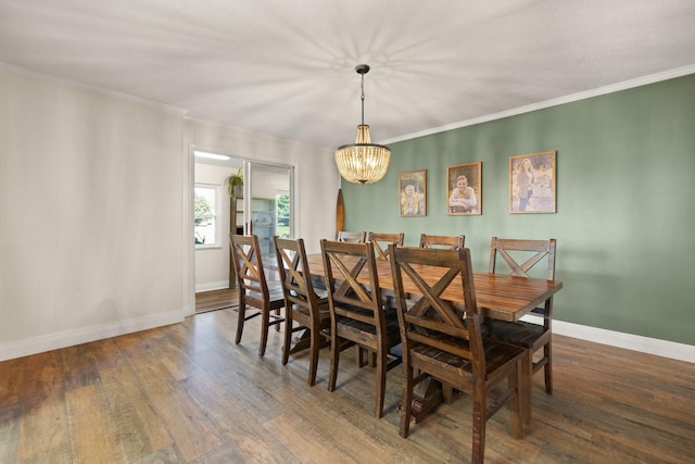 dining room with ornamental molding, a notable chandelier, and dark hardwood / wood-style floors