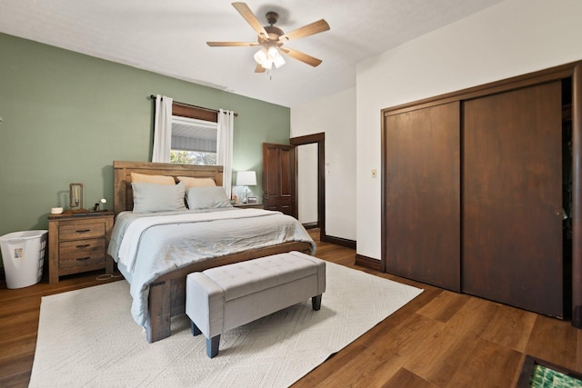 bedroom featuring a closet, dark hardwood / wood-style floors, and ceiling fan