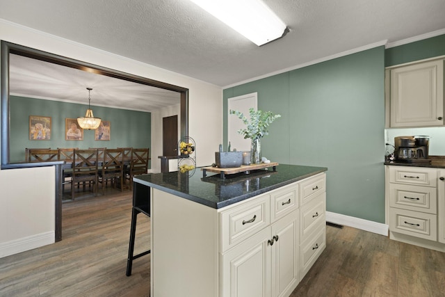 kitchen with a textured ceiling, hanging light fixtures, dark wood-type flooring, and a center island