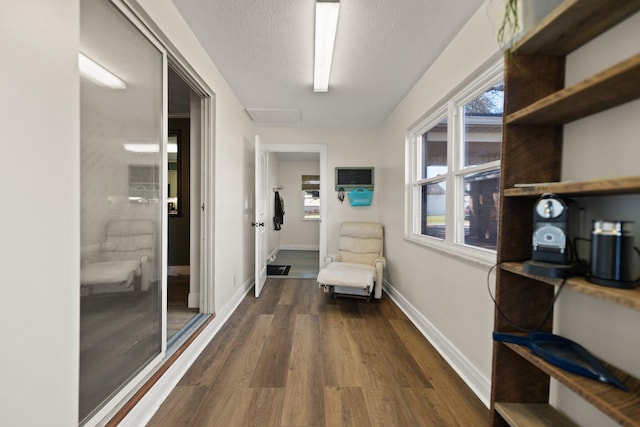 corridor featuring a textured ceiling and dark hardwood / wood-style flooring