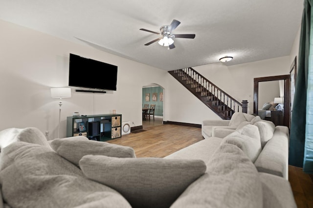 living room with ceiling fan, wood-type flooring, and a textured ceiling