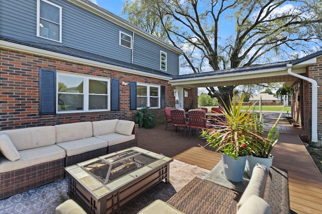 wooden terrace with an outdoor living space with a fire pit