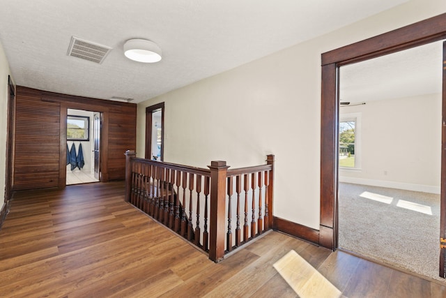 corridor featuring wood-type flooring and a textured ceiling