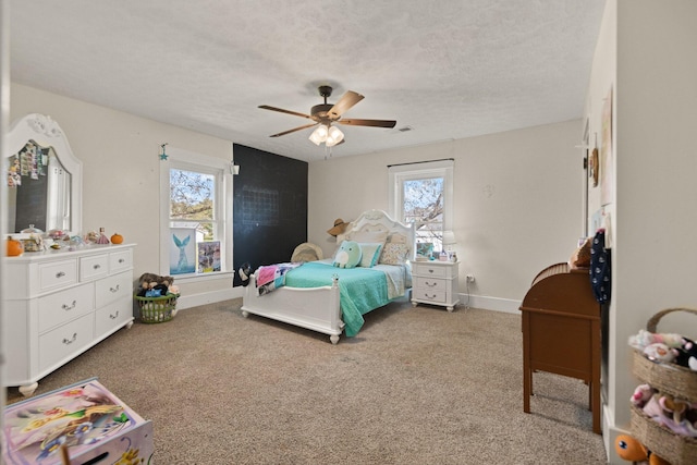 carpeted bedroom featuring a textured ceiling, multiple windows, and ceiling fan