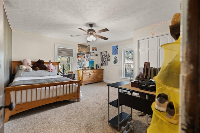 bedroom with multiple windows, ceiling fan, a closet, and a textured ceiling