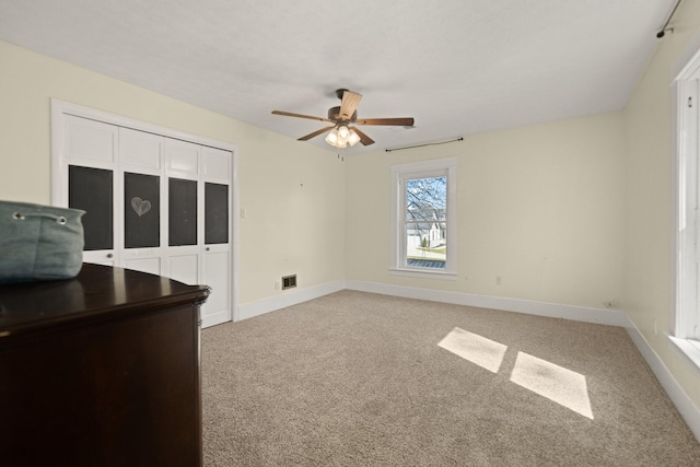 empty room with ceiling fan and light carpet