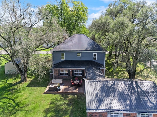 rear view of house with a yard and a wooden deck