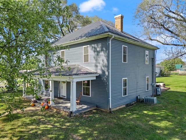 back of house with a yard and central AC unit