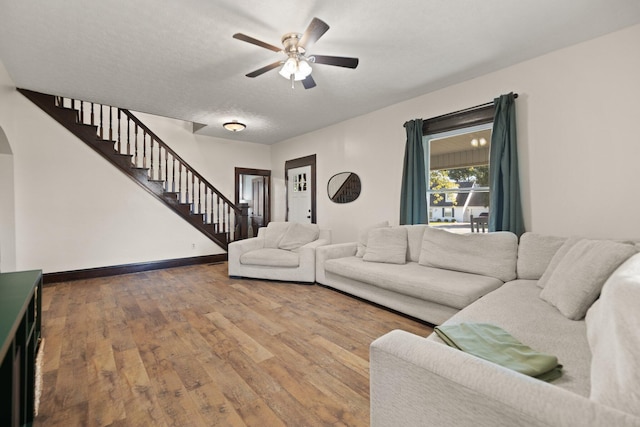 living room featuring ceiling fan, hardwood / wood-style floors, and a textured ceiling